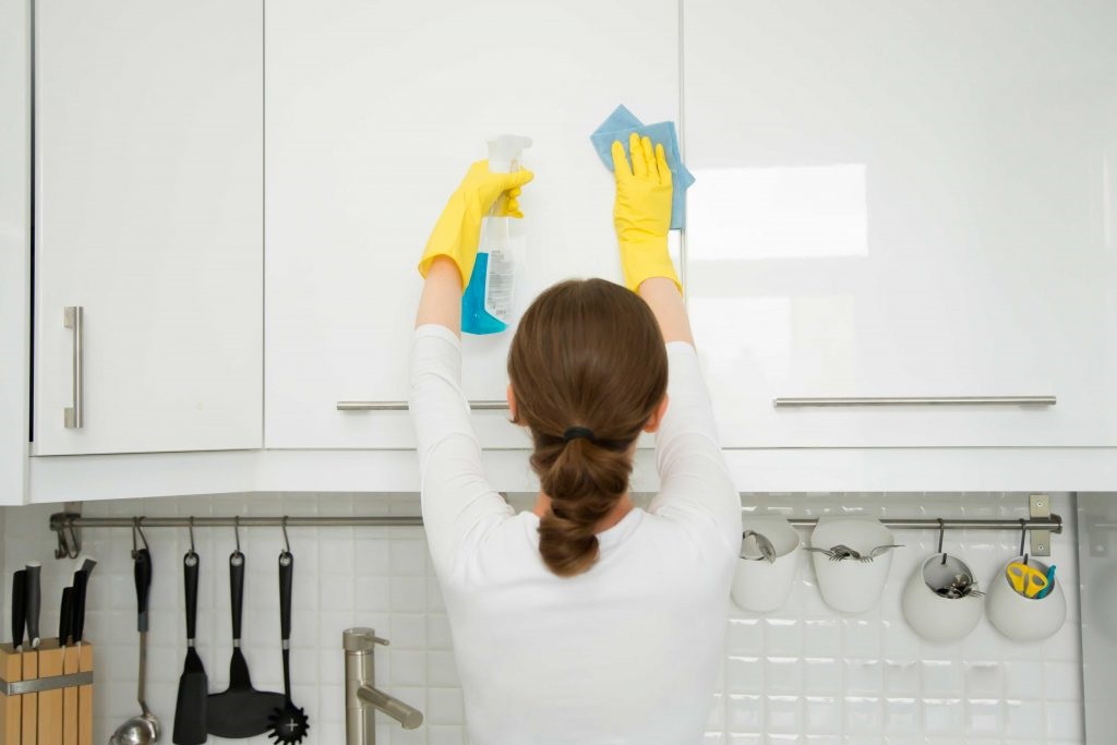 a professional is cleaning kitchen cabinets